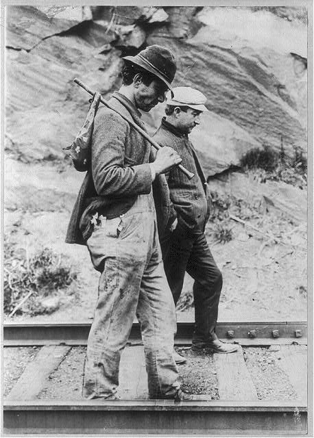 Two hobos walking along railroad tracks after being put off a train