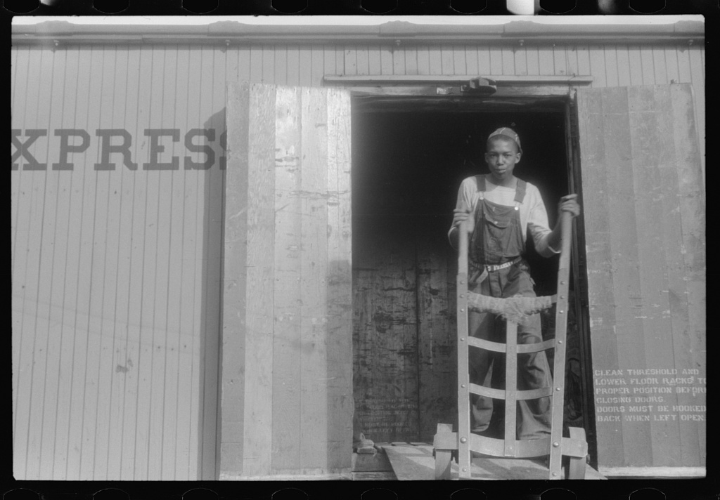 Florida migratory worker loading potato sacks into freight cars, Belcross, North Carolina