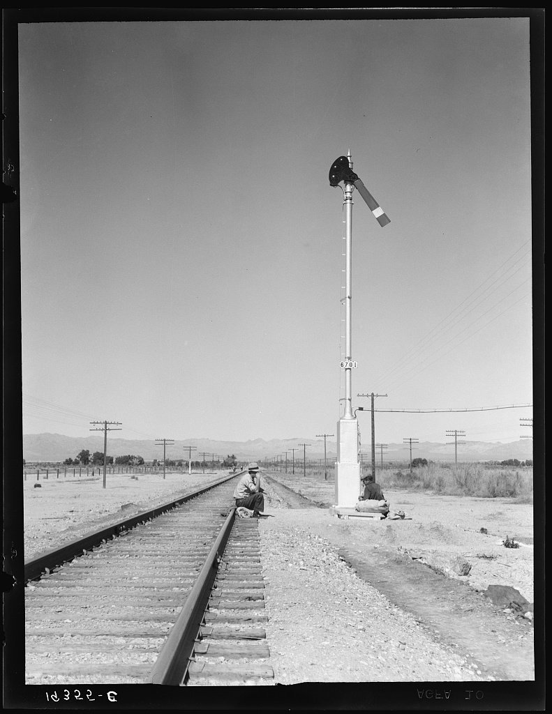 Looking east down the railroad track, near Calipatria, California. Single men, itinerants with "bindles" waiting for the