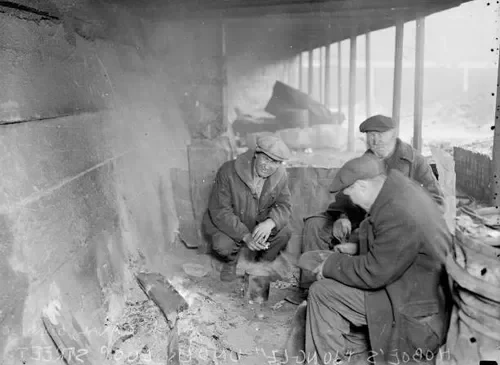 Three men under a shelter