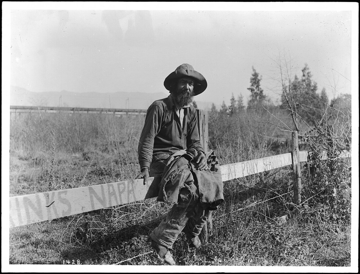 Hobo sitting on a fence, ca. 1920